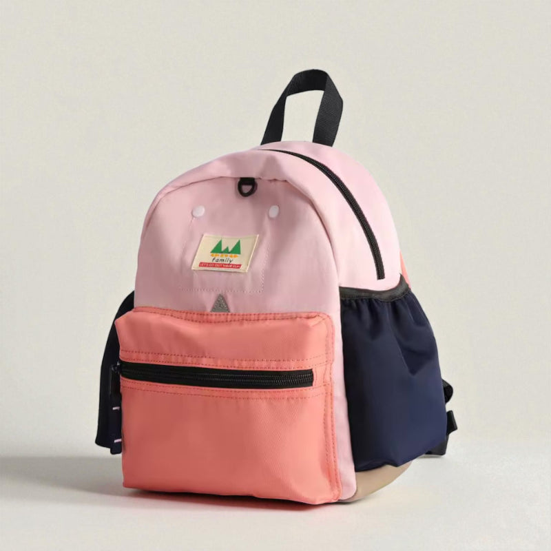 Sac à dos pour enfant rose et corail vu en angle, avec poches latérales bleues