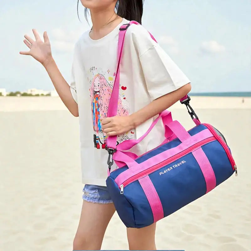 enfant portant le sac piscine enfant Pink Splash en bandoulière sur la plage