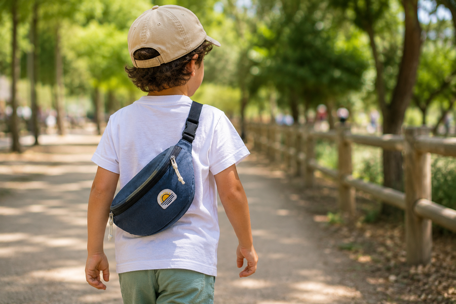 Enfant portant un sac banane bleu pendant une sortie au parc en été