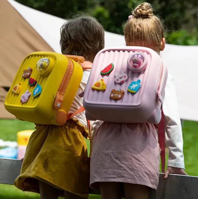 Cartable a roulette rose et jaune au dos d'une fille et garçon