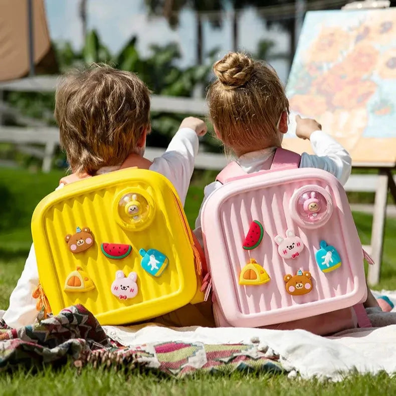 une garçon et une fille avec leur cartable a roulette
