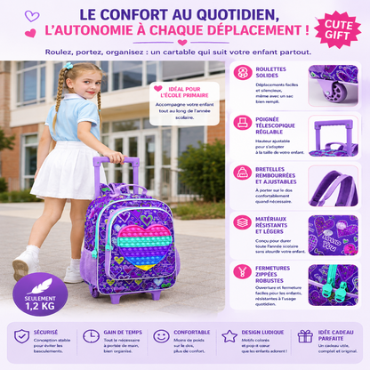 Fillette portant le cartable à roulettes enfant Premier Voyage Violet avec pop-it en forme de cœur devant une école primaire, illustrant le confort, l’autonomie et l’ensemble complet avec sac déjeuner et trousse assortis.