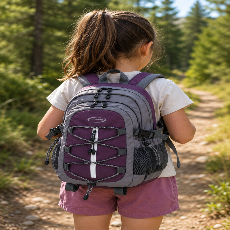 Enfant portant le sac de randonnée violet visuel de dos lors d’une randonnée en montagne