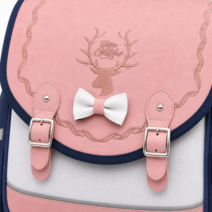 Détail du nœud rayé, des broderies et des boucles du cartable CP fille