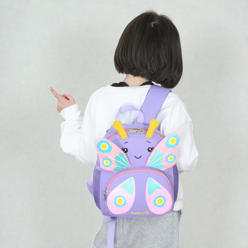 Sac à dos fille maternelle papillon violet porté de dos par une enfant.
