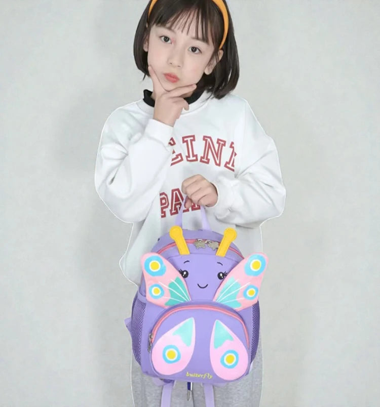 Sac à dos fille maternelle papillon violet porté de face par une enfant.
