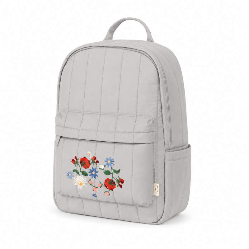 Sac à dos enfant gris perle avec broderie florale et poche latérale, présenté de trois quarts