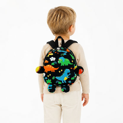 Enfant de maternelle portant un petit sac à dos noir à motifs dinosaures colorés, vue de dos