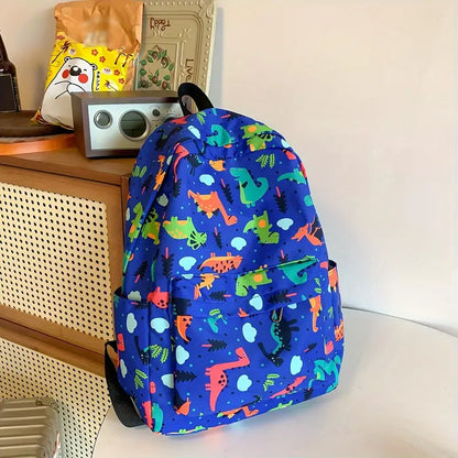 Sac cartable enfant dinosaures bleu posé sur meuble dans une scène intérieure

