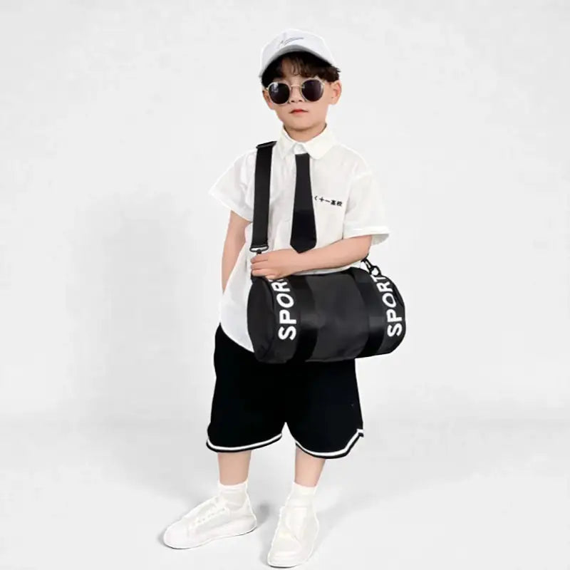 enfant portant le sac de sport enfant garçon Black Sport en bandoulière de face
