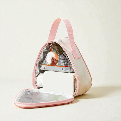 Intérieur du sac gouter isotherme rose, avec boisson et en-cas rangés dans la poche principale.