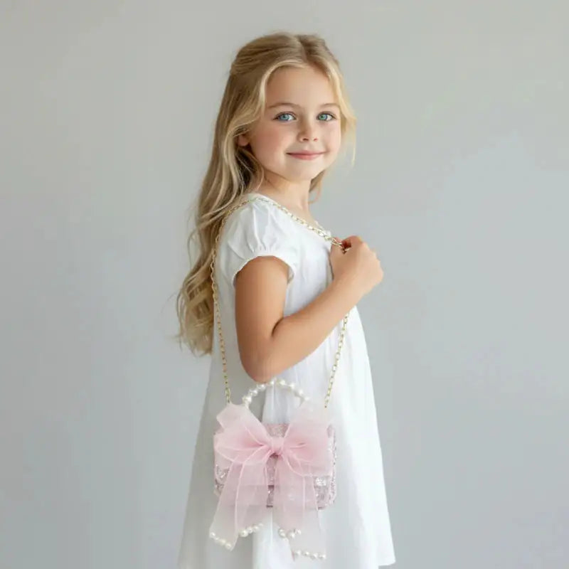 Sac à main pour enfant rose Perle porté par une petite fille