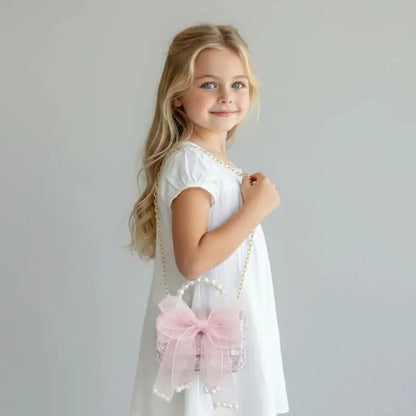 Sac à main pour enfant rose Perle porté par une petite fille