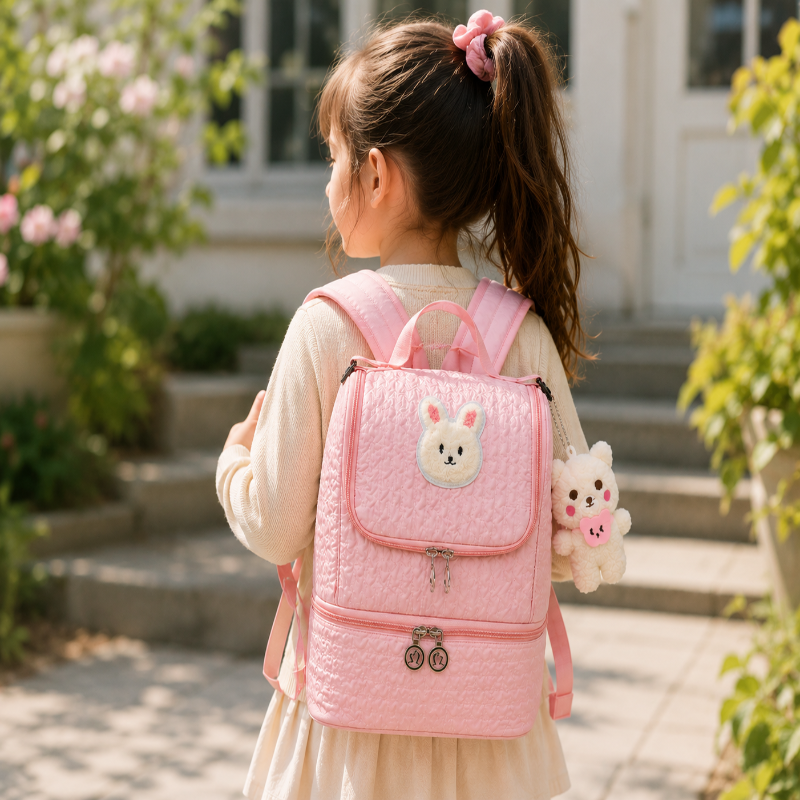 Fille portant un sac à dos enfant isotherme rose lors d’une sortie lifestyle en extérieur.